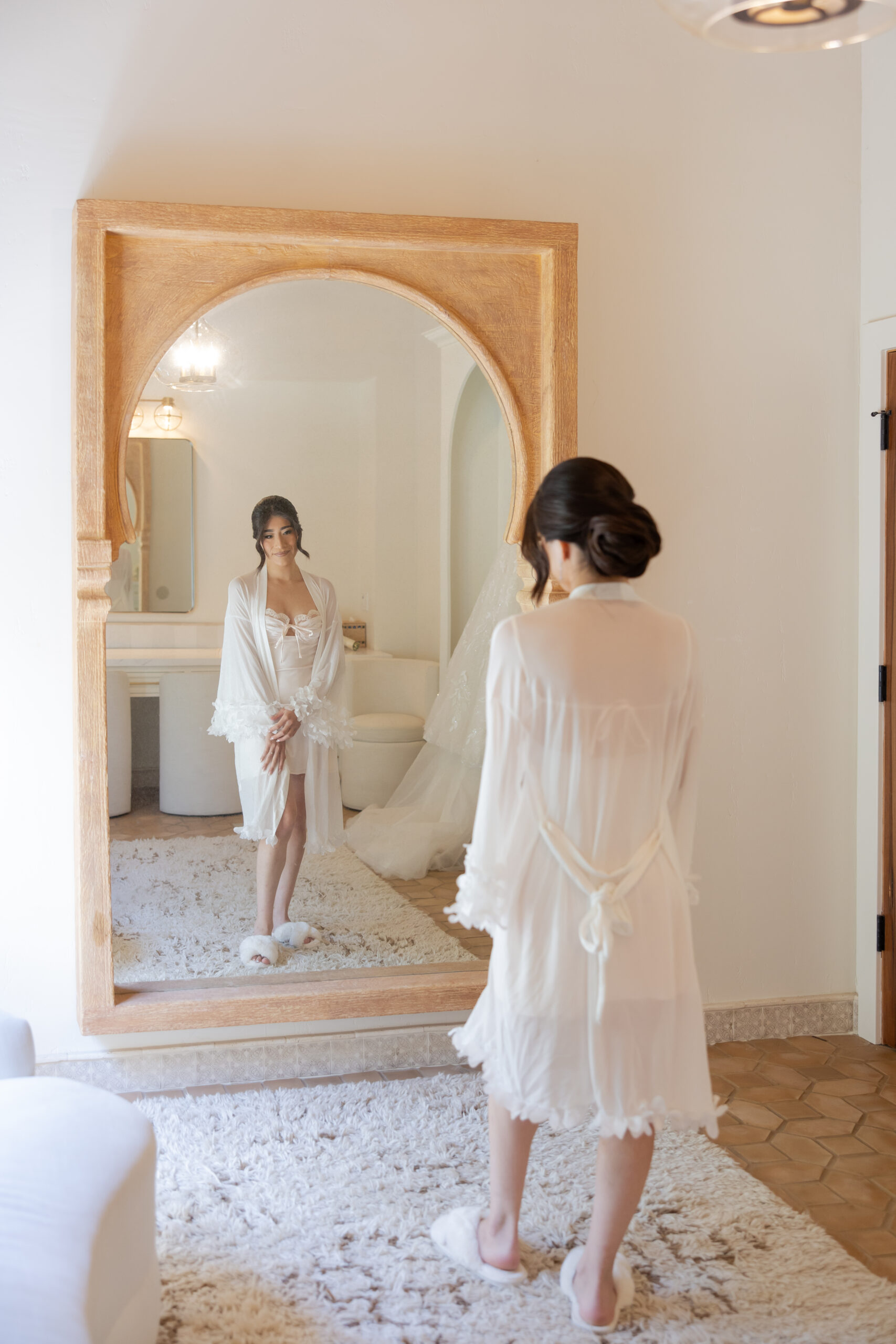 Bride getting ready portrait standing in front of a full-size mirror in the Grand Gimeno bridal suite.