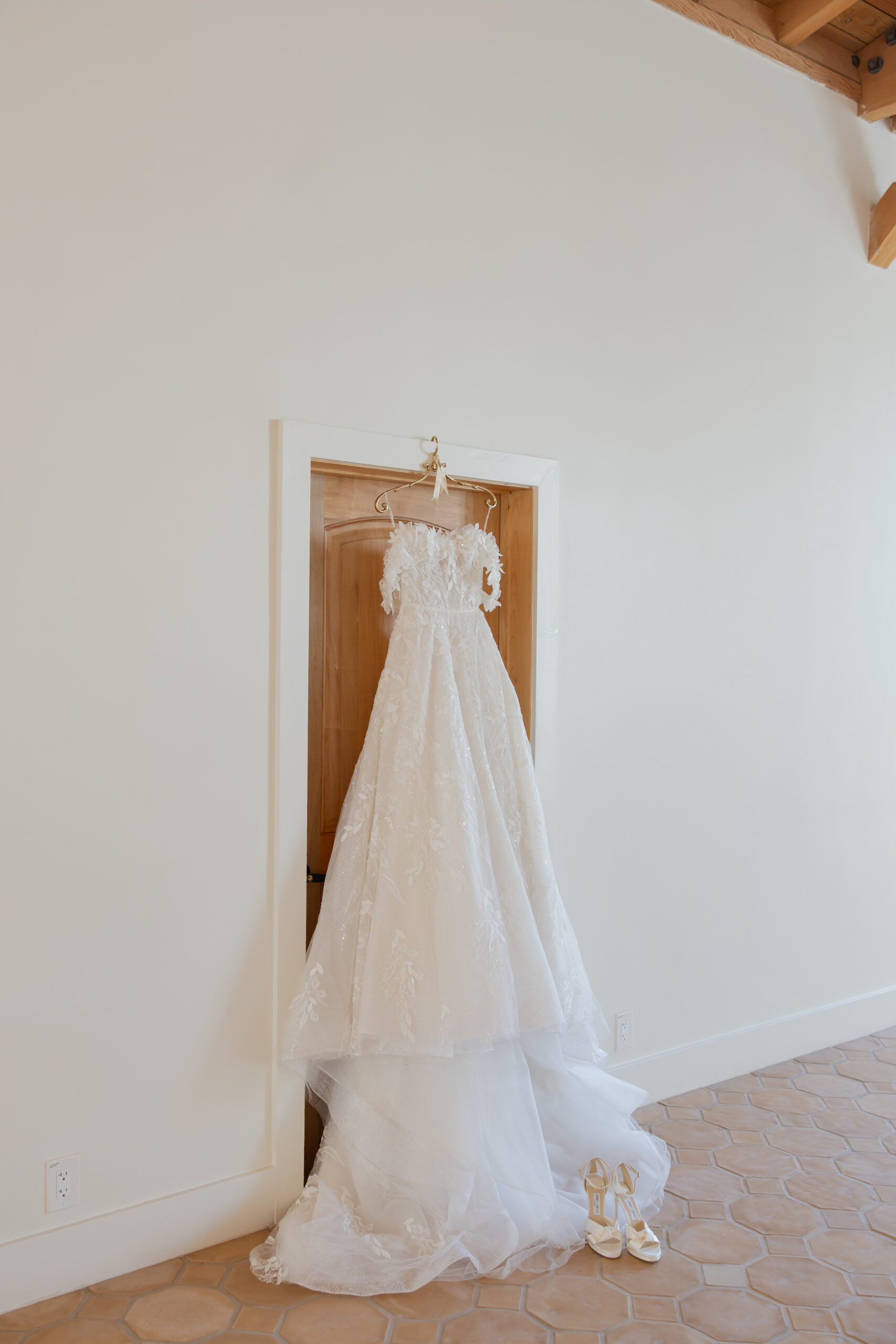 Wedding dress hanging portrait from a wooden door at Grand Gimeno.