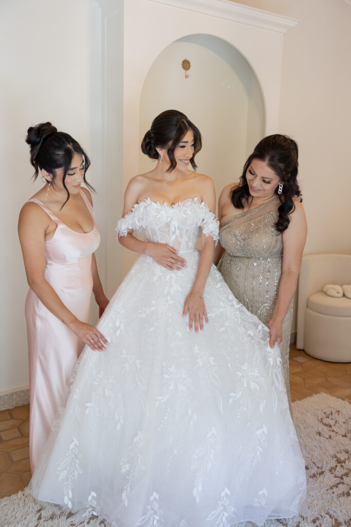 Candid shot of Dalina with her mom and sister in the Grand Gimeno bridal suite after putting on her wedding dress.
