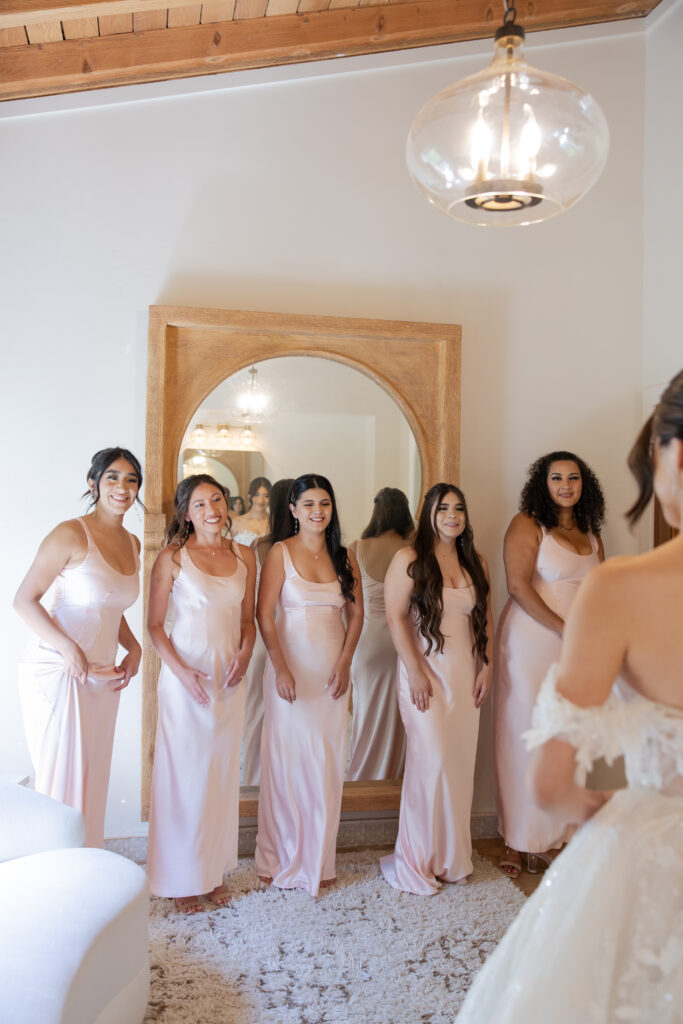 Bridesmaids first look at the bride in her wedding dress in the Grand Gimeno bridal suite.