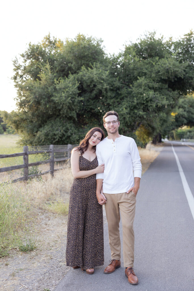 Couple holding hands standing on a road outside Olive + Lavender Farms in Los Olivos, CA. 