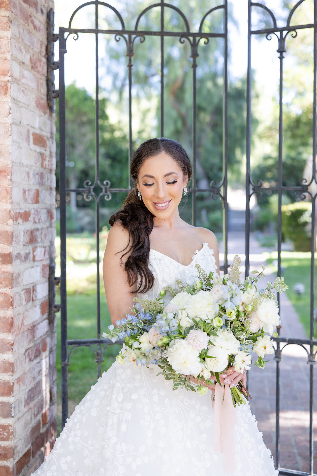 Bride smiling and holding an oversized neutral floral bouquet at Hummingbird Nest Ranch.