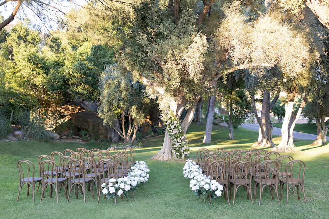Outdoor garden wedding ceremony at Hummingbird Nest Ranch with a floral lined aisle. 