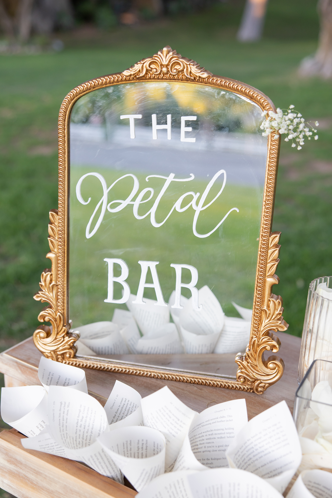 Vintage gold mirror with vinyl lettering that says "The Petal Bar" wedding welcome table decor.