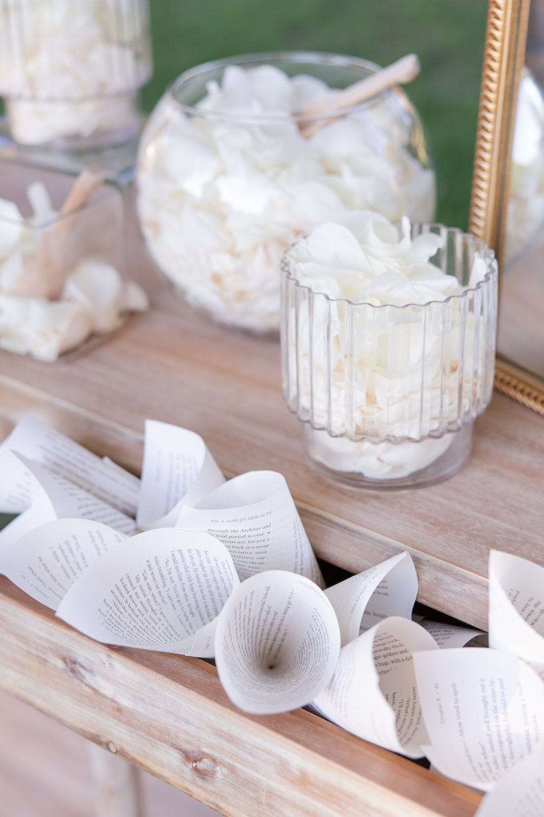 Wedding ceremony petal bar with paper cones and glass jars filled with white flower petals.