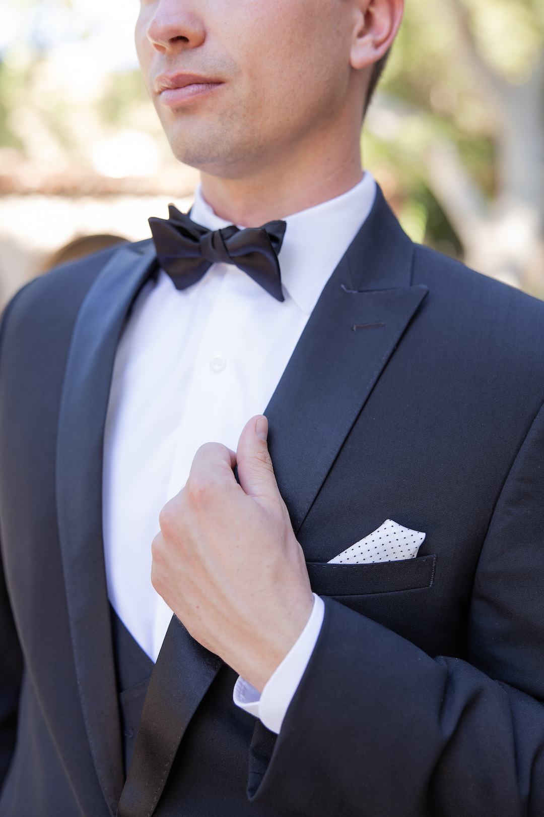 Close up of a groom's classic black attire.