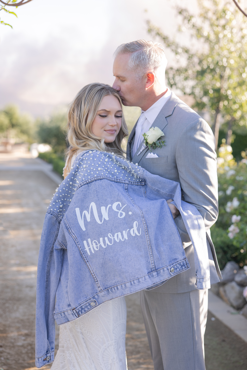 Bride posing with her custom Mrs jean jacket at Tuscan Rose Ranch.