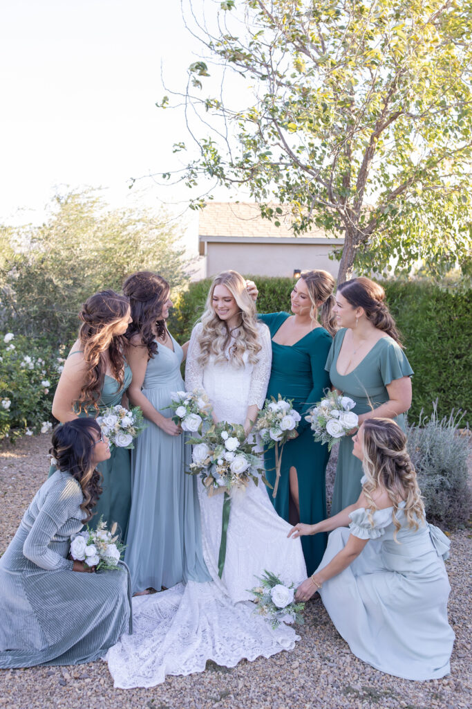 Candid group photo of bridesmaids gathered around the bride at Tuscan Rose Ranch. 