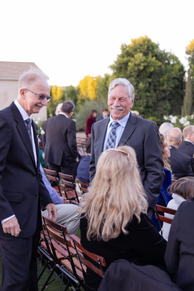 Guests sharing a candid moment pre-ceremony at Tuscan Rose Ranch.