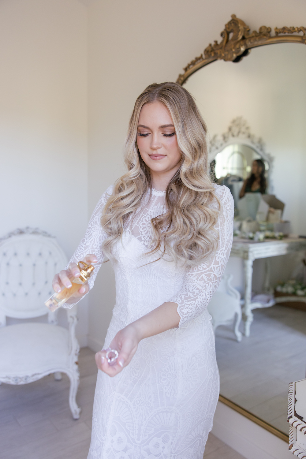 Bride putting on perfume in the Tuscan Rose Ranch bridal suite. 