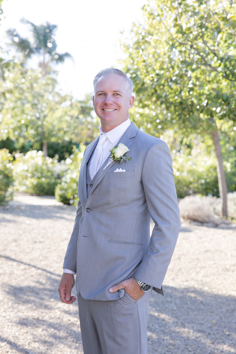 Groom wedding day portrait wearing a grey suite at Tuscan Rose Ranch. 